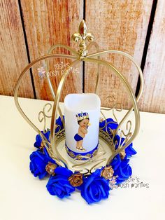 a cup on a plate with blue flowers and a gold holder in the shape of a heart