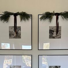 two pictures hanging on the wall with christmas greenery in front of them, and one has a bow tied to it