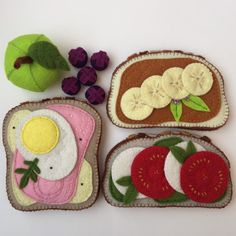 three slices of toast with fruit and an egg on them, one slice has been made to look like a sandwich