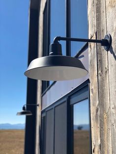 an outdoor light on the side of a building next to a wooden door and window