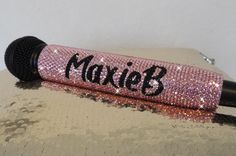 a close up of a pink microphone on a sequinized surface with the word dixie written on it