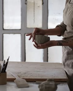 a woman is making something out of clay