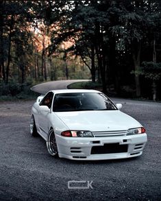 a white car parked in front of some trees