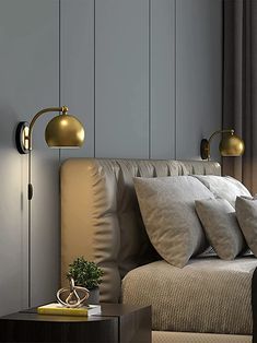 a bed with pillows and two lamps on the wall next to it in a bedroom