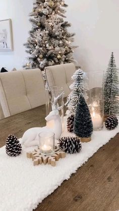 a dining room table decorated for christmas with pine cones, candles and deer figurines