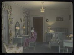 an old photo of a woman sitting in a room