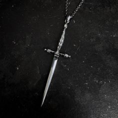 The Nyx Dagger Pendant features a spiral fluted hilt and is modeled after antique stiletto daggers that originated in the 15th century- used in close combat to penetrate armored opponents. Daggers are multifaceted, have an extensive role in mythology and lore, and hold a vast spectrum of meanings and symbolism. From protection, courage, and sacrifice to betrayal, and loss, the dagger's meaning is forever personal-- an ever changing reflection of our internal struggles. Through life's ebbs and fl October Jewelry, Medieval Witch, Infinity Chain, Dagger Necklace, Close Combat, Dagger Earrings, Pretty Knives, Outfit Planning, Cross Earrings