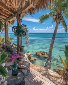 an outdoor dining area overlooking the ocean with palm trees