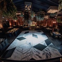 an artisticly designed dance floor is lit up in the middle of a room with tables and chairs