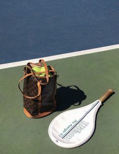 a tennis racket and bag sitting on the court