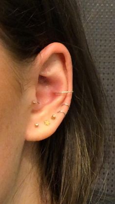 a close up of a person's ear with two small gold stars on it