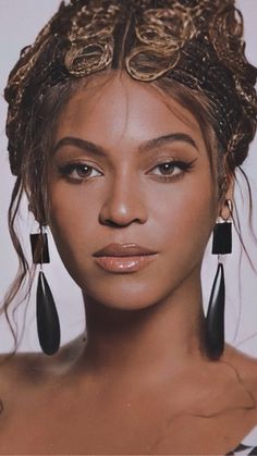 a close up of a person wearing some kind of head piece with earrings on it