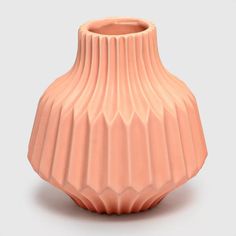 a pink vase sitting on top of a white table