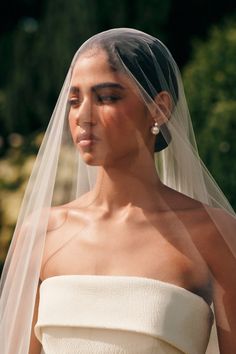 a woman wearing a white wedding dress and veil