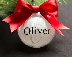 an ornament hanging from a christmas tree with a red ribbon on it's bow