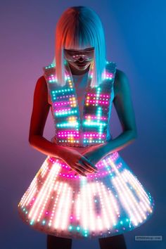 a woman in a dress that has lights all over her body and face, with bright colors on it