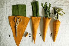 three carrots are cut into triangles and have scissors in them on a sheet of paper