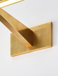 a close up of a wall light on a white wall with a gold colored frame