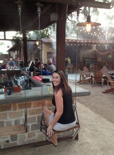 a woman sitting on a bench in front of a bar