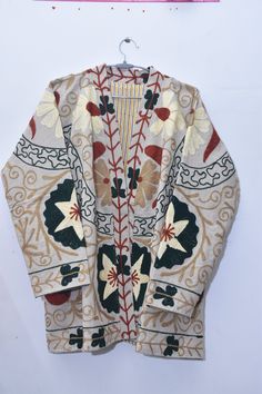 Beautiful short suzani-style kimono jacket, in heavy canvas cotton & hand med embroidery. The kimono jacket has extra cotton lining and can be closed by tying a long belt  A kimono jacket can be worn by men and women (unisex) and is worn oversized. And in excellent condition; nevertheless, small imperfections may occur! These imperfections are hardly noticeable, unless explicitly indicated. Material: cotton Care instructions: professional cleaning only Origin: India This is a handmade artisanal item; minimal difference in color, size and pattern may occur. Although we do our very best to provide clear pictures, minimal differences in color may occur. Embroidered Cotton Kimono For Fall, Folk Style Cotton Kimono For Spring, Traditional Multicolor Embroidered Kimono For Fall, Traditional Cotton Outerwear For Spring, Fall Beige Cotton Kimono, Long Sleeve Multicolor Embroidered Kimono For Fall, Traditional Embroidered Kimono For Fall, Traditional Cream Outerwear For Fall, Traditional Beige Long Sleeve Outerwear