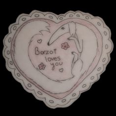 a heart shaped plate with an image of a bird on it's face and the words bozor loves you