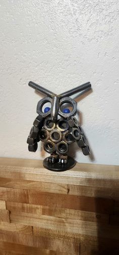 a metal object sitting on top of a wooden shelf next to a white painted wall