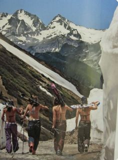 three men with skis and snowboards walking up a mountain