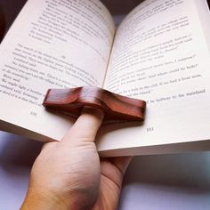 a person holding an open book with a wooden cross on it