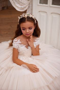 Elevate the elegance of your little one's special day with the Pentelei Couture 3627 Lace Embroidered Tulle Flower Girl Dress. This stunning gown features a sheer illusion off the shoulder neckline adorned with intricate embroidered crystal accents, adding a touch of sparkle to her look. The voluminous floor length skirt is sure to make her feel like a princess, with multiple tiers of ruffled tulle creating a dreamy and ethereal silhouette. Let her shine and steal the show in this exquisite ense First Communion Pictures, Designer First Communion Dresses, 1st Communion Dresses, Comunion Dress, Communion Hair, Communion Headpiece, Girls Communion Dresses, Flower Girl Crown, Tulle Flower Girl