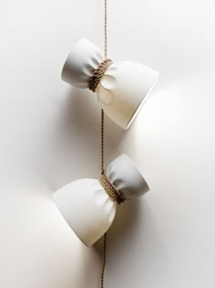 two white lamps are hanging on the wall