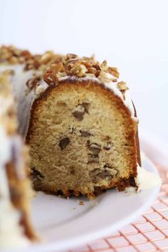 a piece of cake with white frosting and nuts on top