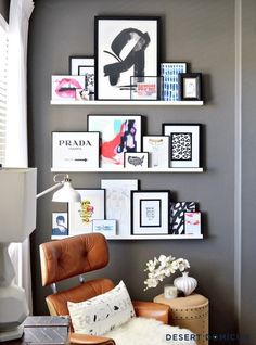 a living room filled with furniture and framed pictures on the wall above a leather chair