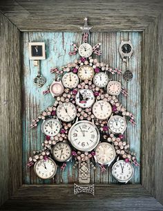 there is a christmas tree made out of clocks in a frame with pink flowers on it