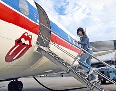 a woman walking up the stairs to an airplane