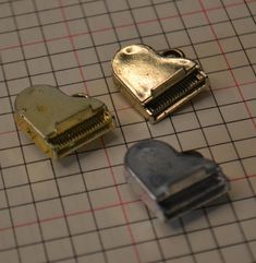 there are three pieces of metal that have been placed on a gridded table top