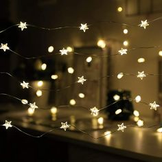 a kitchen counter topped with lots of white stars hanging from it's side and lights on the ceiling