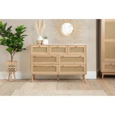 a wooden dresser sitting next to a potted plant on top of a hard wood floor