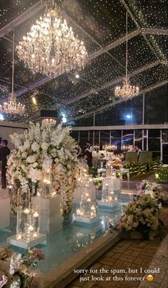 a room filled with lots of white flowers and candles