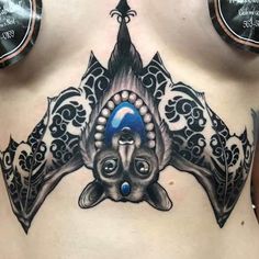 a woman's stomach with an artistic tattoo design on it