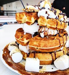 a stack of waffles with marshmallows and chocolate syrup on top