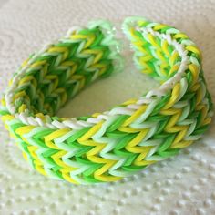 a green and yellow bracelet sitting on top of a white table