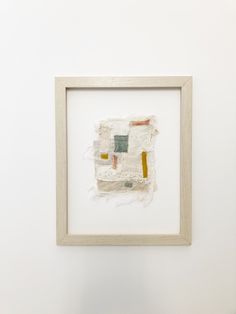 a white framed artwork hanging on the wall