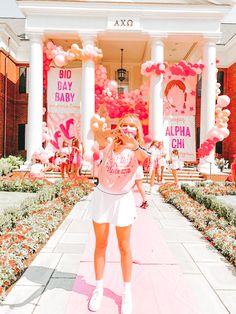 a woman standing in front of a building with balloons