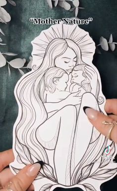 a woman is holding a paper cutout with the image of a mother and child