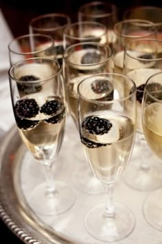 there are many glasses that have some food in them on the tray and one is filled with champagne