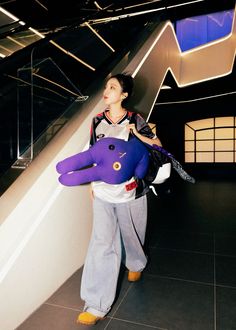 a man holding a large purple stuffed animal