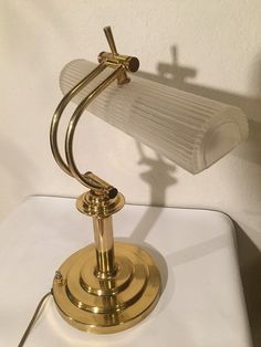 a lamp that is sitting on top of a white table next to a light bulb