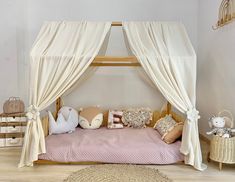 a canopy bed with pillows and stuffed animals on it