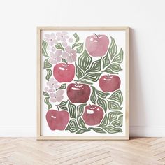 an apple print with leaves and flowers in a wooden frame on the floor next to a wall