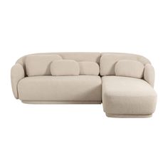 a large sectional couch with pillows on the top and bottom, sitting in front of a white